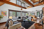 Step into luxury with this stunning property featuring a spacious living area with high ceilings and exposed wooden beams.