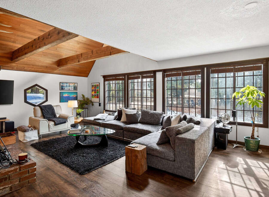 This stunning living room boasts a cozy atmosphere with its inviting sectional sofa and a plush, dark-colored rug.