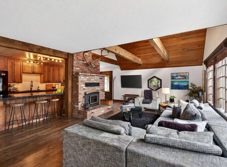 This stunning property boasts a cozy living space with a brick fireplace and a modern kitchen.