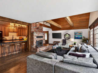 This stunning property boasts a cozy living space with a brick fireplace and a modern kitchen.