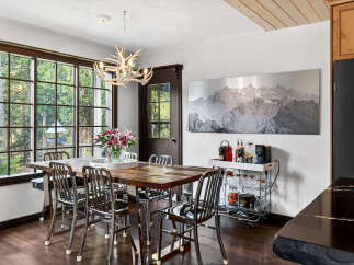 This stunning dining room boasts a rustic wooden table, perfect for hosting gatherings.
