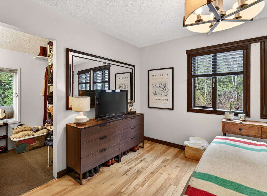 Discover the charm of this inviting bedroom, featuring a stylish dresser, a large mirror, and a cozy ambiance.