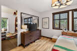 Discover the charm of this inviting bedroom, featuring a stylish dresser, a large mirror, and a cozy ambiance.