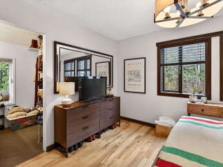 Discover the charm of this inviting bedroom, featuring a stylish dresser, a large mirror, and a cozy ambiance.