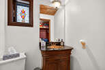 This charming bathroom features a unique stained-glass window, adding a touch of elegance and character.