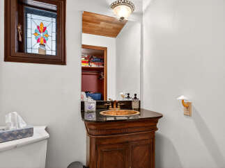 This charming bathroom features a unique stained-glass window, adding a touch of elegance and character.
