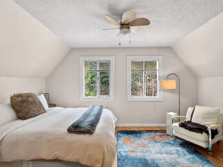 This cozy bedroom features a comfortable bed with a plush throw and pillow, perfect for relaxing.