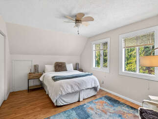 This charming bedroom offers a cozy retreat with its inviting ambiance and natural light.