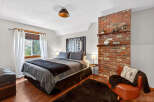 This cozy bedroom features a stylish brick accent wall, adding a touch of rustic charm to the space.