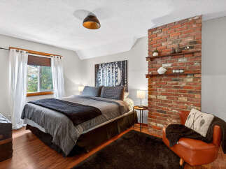 This cozy bedroom features a stylish brick accent wall, adding a touch of rustic charm to the space.