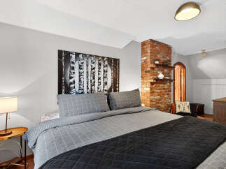 Discover the charm of this inviting bedroom, featuring a cozy bed adorned with stylish bedding.