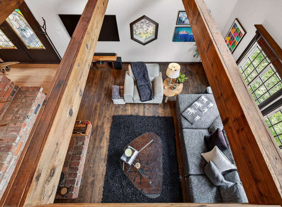 Step into this stunning home featuring a cozy living area with a brick fireplace and exposed wooden beams.