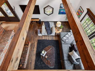 Step into this stunning home featuring a cozy living area with a brick fireplace and exposed wooden beams.