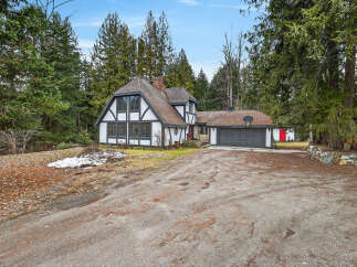 Nestled amidst lush greenery, this charming property boasts a unique Tudor-style architecture.