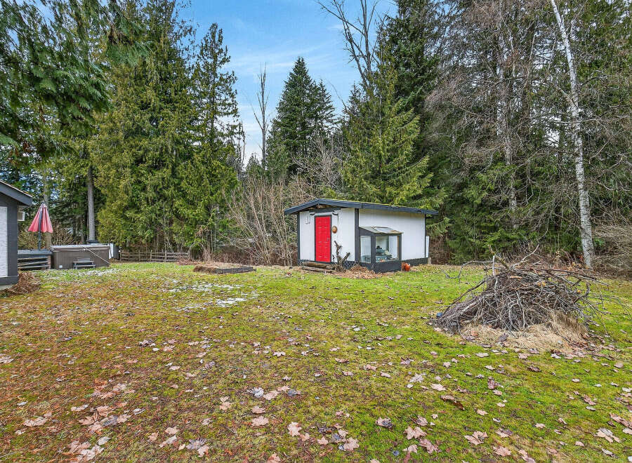 Discover the charm of this property, featuring a cozy cabin with a vibrant red door.