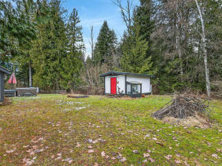 Discover the charm of this property, featuring a cozy cabin with a vibrant red door.