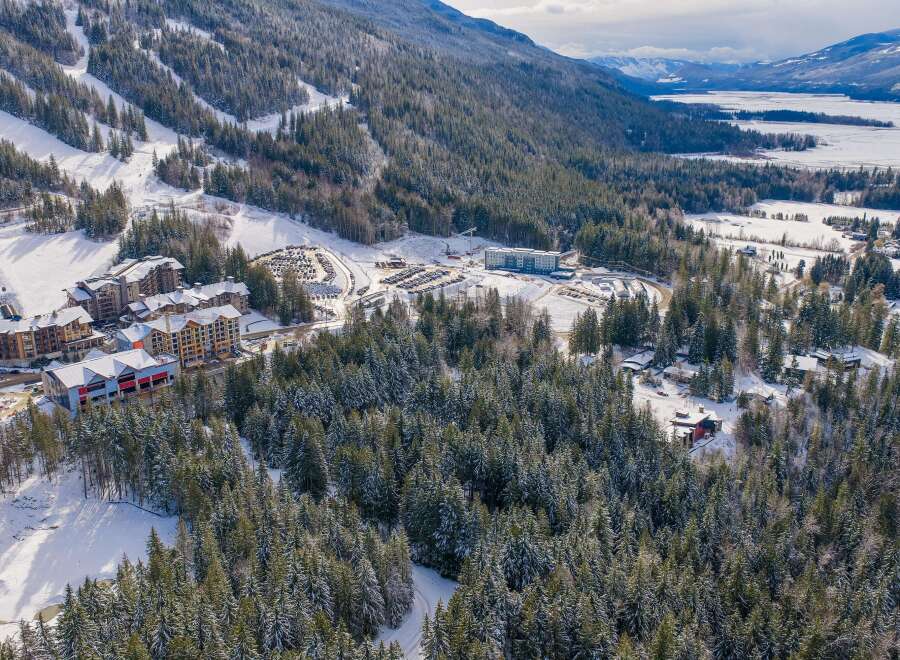 Discover a winter wonderland in this stunning aerial view! This property boasts a prime location near a ski resort, offering unparalleled access to the slopes.