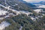 Discover a winter wonderland in this stunning aerial view! This property boasts a prime location near a ski resort, offering unparalleled access to the slopes.