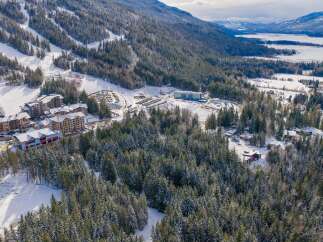 Discover a winter wonderland in this stunning aerial view! This property boasts a prime location near a ski resort, offering unparalleled access to the slopes.
