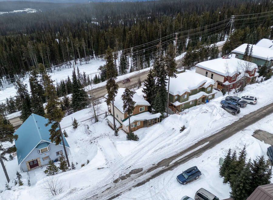 Nestled in a serene winter wonderland, this property boasts charming homes with snow-covered roofs.