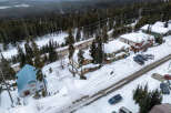 Nestled in a serene winter wonderland, this property boasts charming homes with snow-covered roofs.