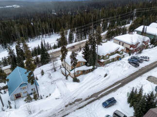 Nestled in a serene winter wonderland, this property boasts charming homes with snow-covered roofs.