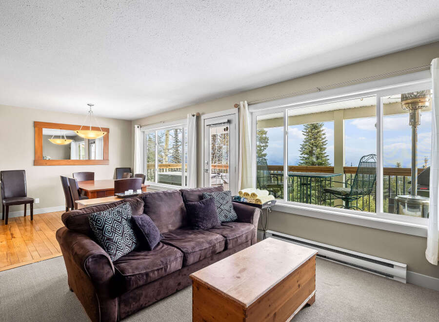 This stunning property boasts a cozy living room with a comfortable sofa and ample natural light.