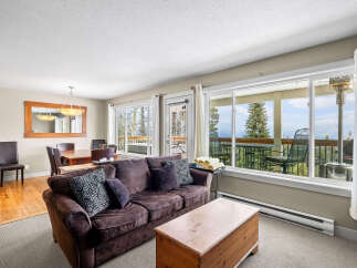 This stunning property boasts a cozy living room with a comfortable sofa and ample natural light.