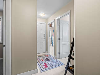 Step into this inviting entryway, showcasing a stylish rug and neutral walls.