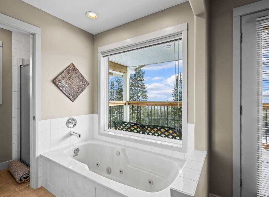 Enjoy the tranquility of this luxurious bathroom featuring a spa-like soaking tub.