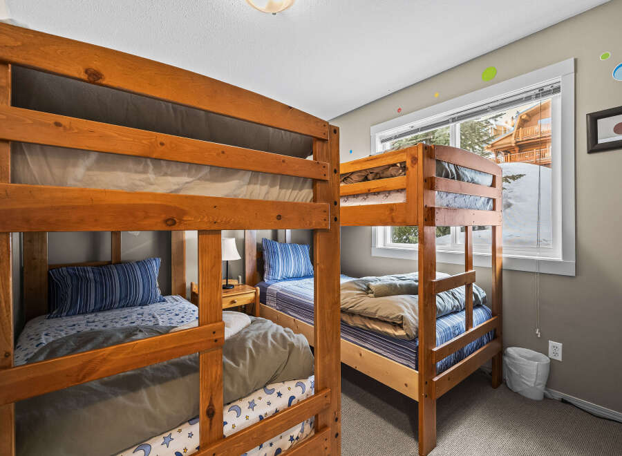 This cozy bedroom features two sets of bunk beds, perfect for accommodating multiple guests or family members.
