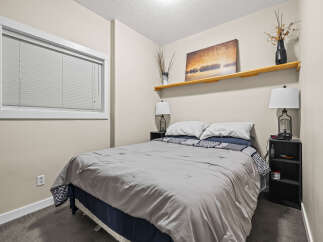 This cozy bedroom offers a serene retreat with its neutral color palette and inviting ambiance.