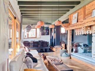 Discover the charm of this stunning property, featuring a spacious living area with a cozy fireplace and exposed wooden beams.