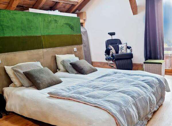 Discover the charm of this unique property, featuring a cozy bedroom with a skylight and exposed wooden beams.
