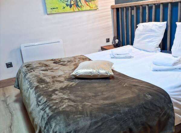This cozy bedroom features a comfortable bed with soft linens and a stylish throw blanket, perfect for a relaxing stay.