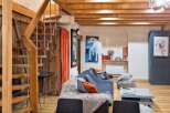 This charming property boasts a cozy living space with exposed wooden beams and a unique staircase.