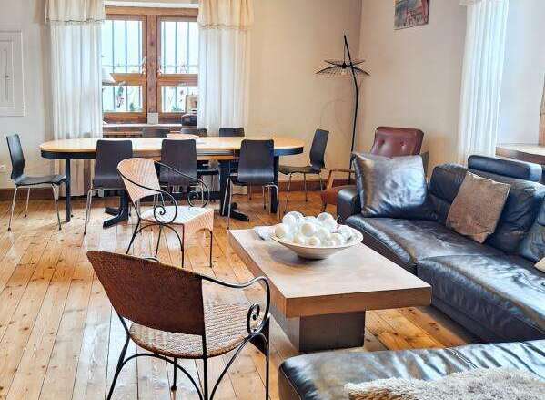 Discover the charm of this stunning property, featuring a spacious living area with a stylish dining table and comfortable seating.