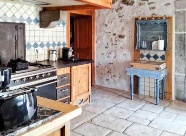 Discover the charm of this rustic kitchen, featuring exposed wooden beams and stone walls that exude warmth and character.