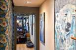Discover the charm of this inviting hallway, featuring elegant wooden floors and artistic wall decor.