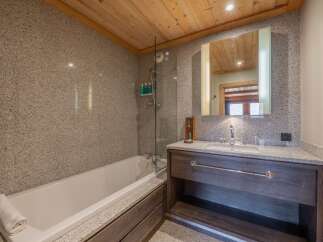 This luxurious bathroom features a sleek design with a modern vanity and a spacious bathtub.