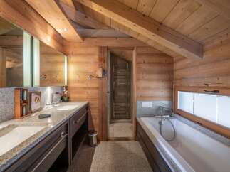 Experience luxury in this stunning bathroom featuring a sleek double vanity with granite countertops and ample storage.