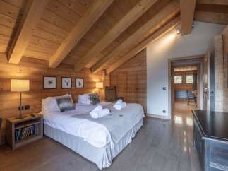 Experience the warmth and charm of this stunning bedroom, featuring exquisite wooden accents and a cozy ambiance.