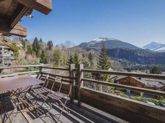 Enjoy breathtaking mountain views from this charming chalet balcony.