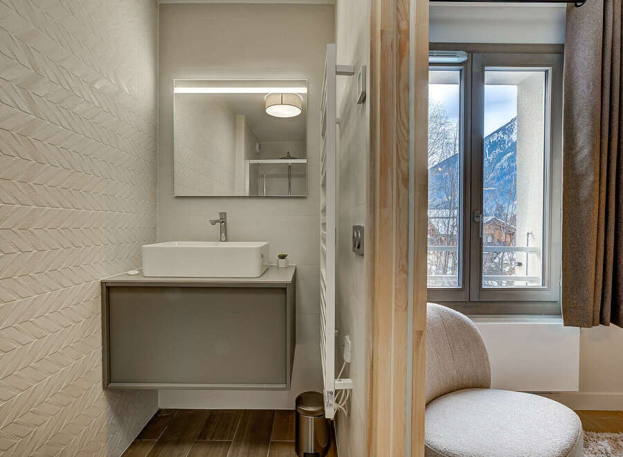 This modern bathroom boasts a sleek design with a floating vanity and a stylish rectangular sink.
