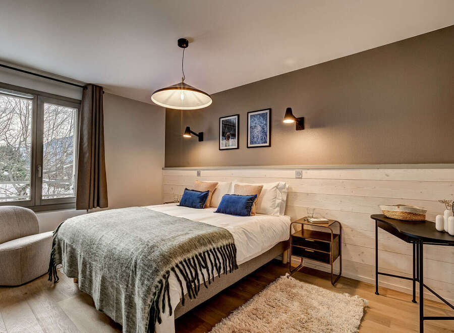 This cozy bedroom features a comfortable bed with plush pillows and a stylish throw blanket.