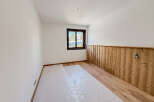This inviting room features a warm wooden accent wall and hardwood flooring, creating a cozy and stylish atmosphere.
