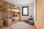 This cozy bedroom features a custom-built wooden bunk bed, perfect for maximizing space.