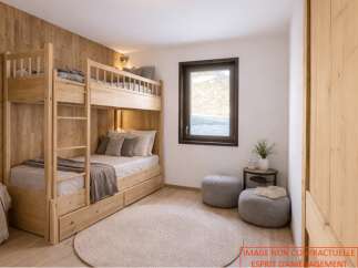 This cozy bedroom features a custom-built wooden bunk bed, perfect for maximizing space.
