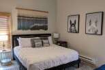 Step into this inviting bedroom, featuring a stylish black bed frame and a cozy, patterned rug.