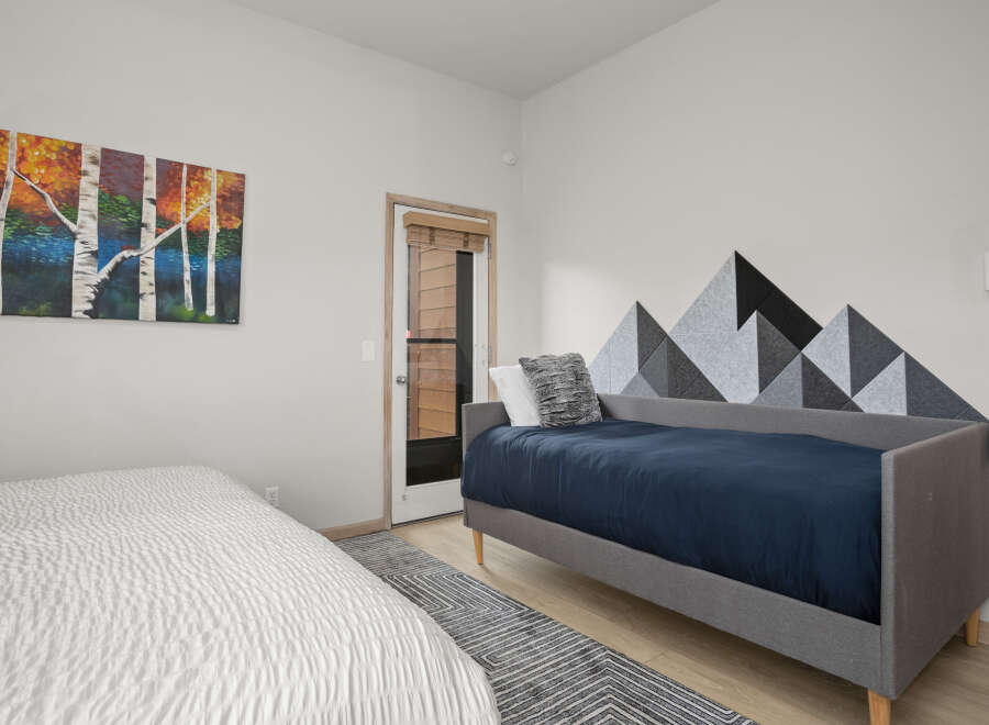 This cozy bedroom features a modern design with a unique mountain-shaped wall decor.